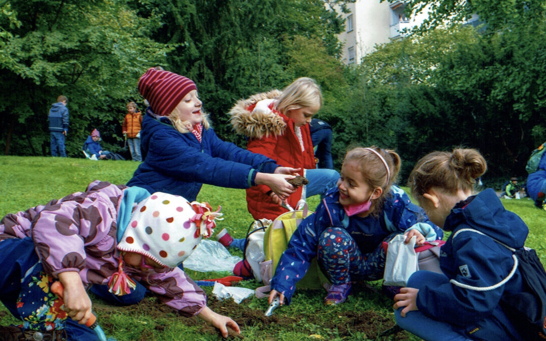 Kinder pflanzen Krokusse im Park